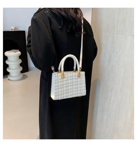 Detail of tweed crossbody bag in cream white with woven texture and gold chain strap