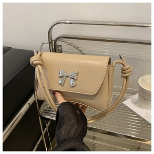 Détails du sac à main beige avec nœud en métal argenté et bandoulière à nœud unique