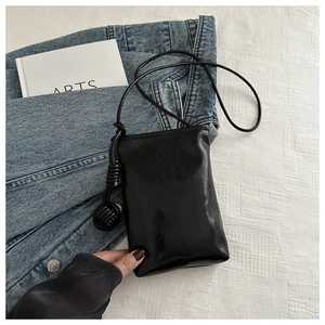 Détail du sac à bandoulière en cuir PU noir froissé avec bandoulière à nœud élégante