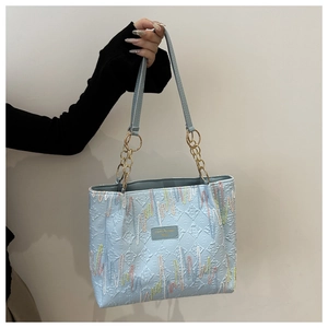 Détail du cabas bleu clair avec texture losange 3D et broderie ondulée colorée