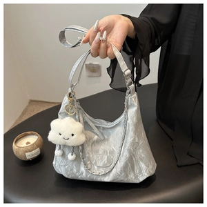 Detail of silver metallic wrinkled tote bag with cute plush cloud charm and chain