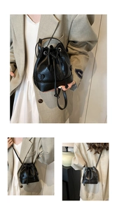 Detail of black drawstring bucket bag with heart patch and adjustable shoulder strap