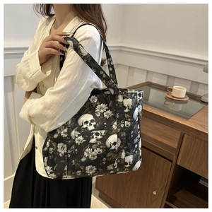 Detailed side view of large skull and flower print tote bag worn on a shoulder