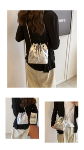 Close-up of metallic silver drawstring bucket bag with heart detail and thin strap