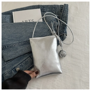 Petit sac de téléphone argenté métallisé avec boule tressée et fine bandoulière