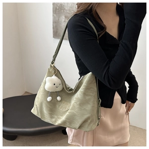 Détail du cabas vert clair plissé avec un adorable pendentif nuage en peluche