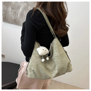 Detail showing light green pleated shoulder bag with soft nylon texture and cloud charm