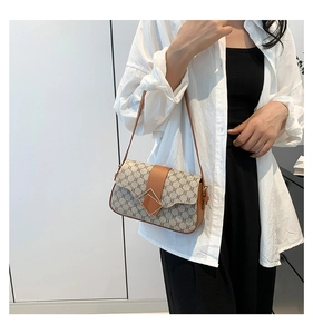 Détail du sac à bandoulière vintage avec boucle en métal et lanière en cuir sur modèle