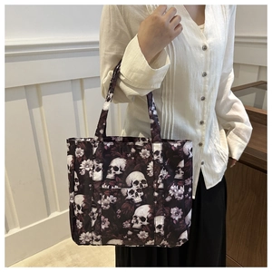 Close-up of gothic skull and floral print on a retro lightweight tote bag worn by model