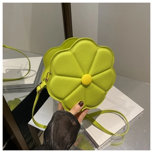 Detail of neon green flower-shaped crossbody bag with yellow center on mirror surface