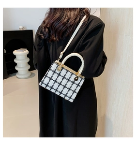 Modern black and white plaid tweed small box bag worn by model in minimalist studio