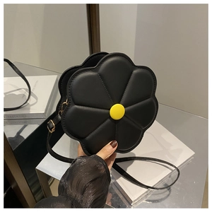 Detail of black 3D flower shoulder bag featuring a yellow center and stitched petals