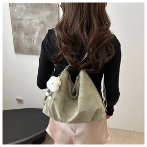 Detail of light green PU leather tote bag featuring a cute white cloud plush pendant