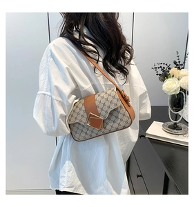 Détail du sac à bandoulière en toile vintage avec garniture en cuir brun et fermoir métal