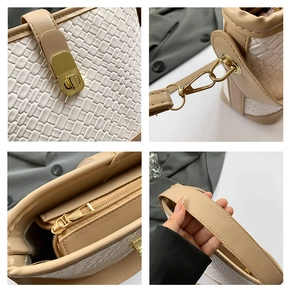 Detail of woven leather texture, gold twist-lock, and metal hardware on a bucket bag