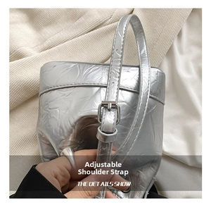 Detail of adjustable silver metallic strap buckle on pleated crossbody bucket bag