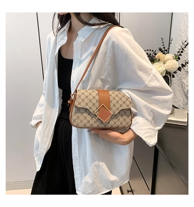 Détail du sac à bandoulière vintage avec motif monogramme et garniture en cuir brun