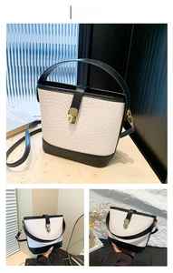 Detail of two-tone bucket bag with black leather base and gold twist lock closure