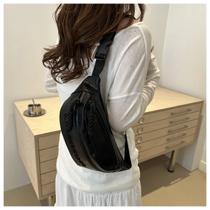 Détail du sac de poitrine noir avec bandoulière réglable et logo embossé élégant