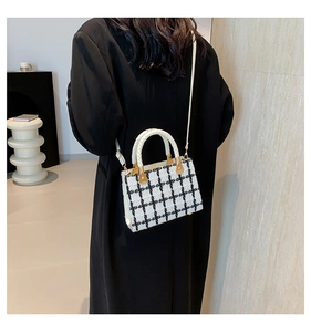 Detail of checkered tweed crossbody bag worn by a model in a minimalist setting