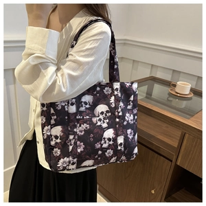 Chic tote bag featuring a realistic skull and white floral print styled on a model