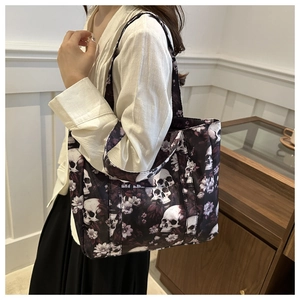 Side view of a large tote bag with skull and purple floral print on a model