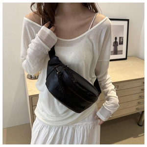 Détail d'un sac bandoulière tendance en cuir PU noir avec lettrage gaufré et sangle