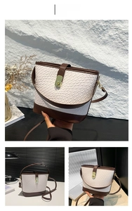 Detail of white woven texture and brown leather trim on a stylish bucket bag