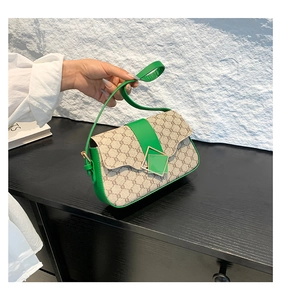 Détail du sac porté épaule monogramme vintage avec bordure en cuir vert et boucle