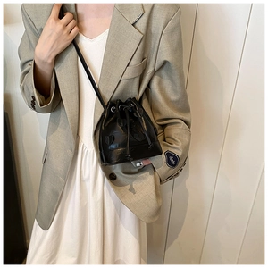 Detail of a black drawstring bucket bag with 3D heart appliques on a white dress