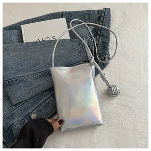 Détail du sac de téléphone argenté laser avec finition irisée tendance et breloque tressée