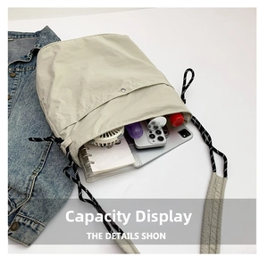 Interior storage view of nylon tote bag with drawstring holding fan, notebook and phone