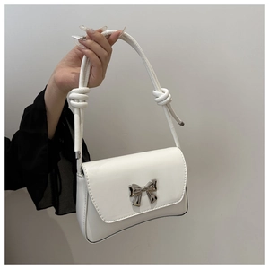 Détail du sac à bandoulière en cuir blanc avec boucle nœud argentée et bandoulière corde