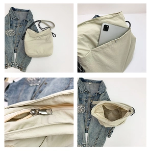 Detail view of beige nylon tote bag showing front pocket storage and woven rope strap