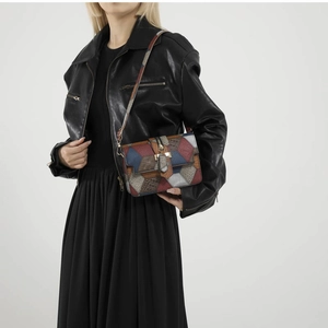 Colorful patchwork crossbody bag with metallic lock closure and stylish leather textures