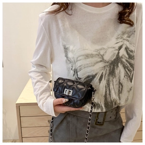 Détail du mini sac matelassé noir avec fermoir rotatif argenté et bandoulière chaîne