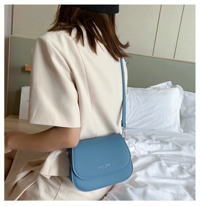 Blue saddle bag in matte PU leather shown on model for a stylish casual daily look