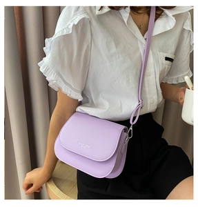 Close-up of lavender leather saddle bag with white Fashion Trend text print detail