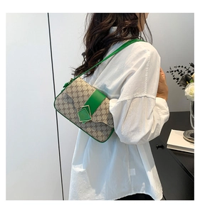 Gros plan d'un sac porté épaule monogramme vert avec boucle en métal sur un mannequin