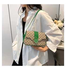 Détail du sac bandoulière vintage avec bordure en cuir vert et boucle carrée