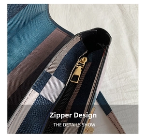 Détail d'un sac à carreaux multicolore avec fermeture éclair en métal doré et coutures