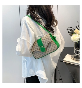 Détail du sac à bandoulière vintage vert et beige avec motif monogramme et boucle dorée