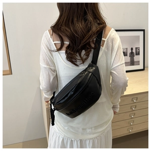 Close-up of black PU leather waist bag featuring embossed logo and adjustable strap
