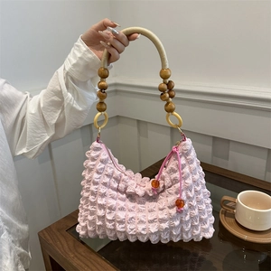 Sac à bandoulière rose texture popcorn avec poignée unique en perles de bois et métal
