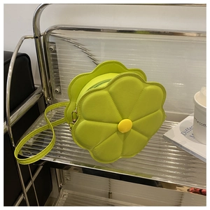 Close-up of lime green flower-shaped crossbody bag with yellow center and zipper detail