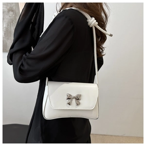 Gros plan du sac blanc avec boucle nœud en métal argenté et bandoulière à nœuds