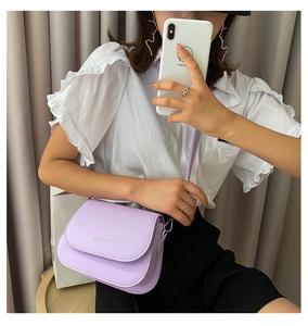 Modern lavender saddle bag worn by a model in a minimalist stylish indoor setting