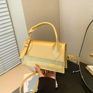 Mustard yellow minimalist square handbag with top handle and crossbody strap in warm lighting
