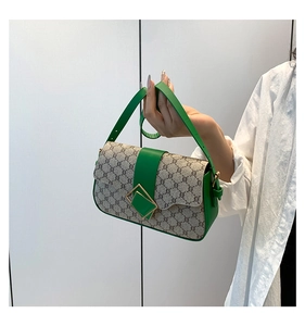 Détail du sac à bandoulière vintage avec bordure en cuir vert et boucle dorée