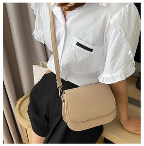Close-up of khaki faux leather saddle bag with Fashion Trend logo and silver metal hardware